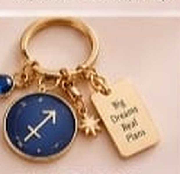 Sagittarius zodiac keychain with a gold ring, enamel sign disc, crystal, star charm and tag reading Big Dreams Real Plans